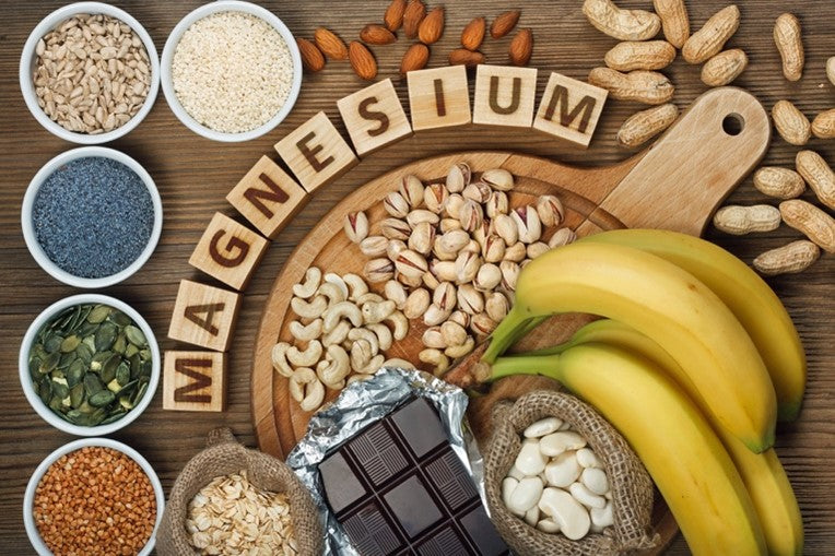 Magnesium-rich foods and supplement capsules arranged on a wooden surface