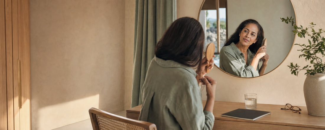 Woman gently brushing her hair in a calm morning dressing area while planning her GLP-1 off-ramp