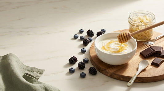 Modern gut health flat-lay with probiotic yogurt bowl, berries, sauerkraut, and honey